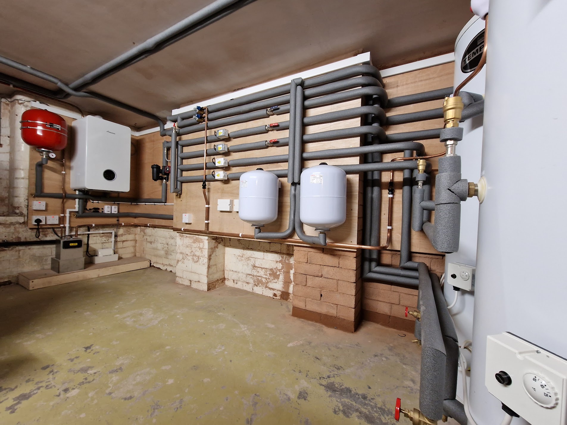 Unvented cylinder tie-in with insulated manifold, zone-valve wall