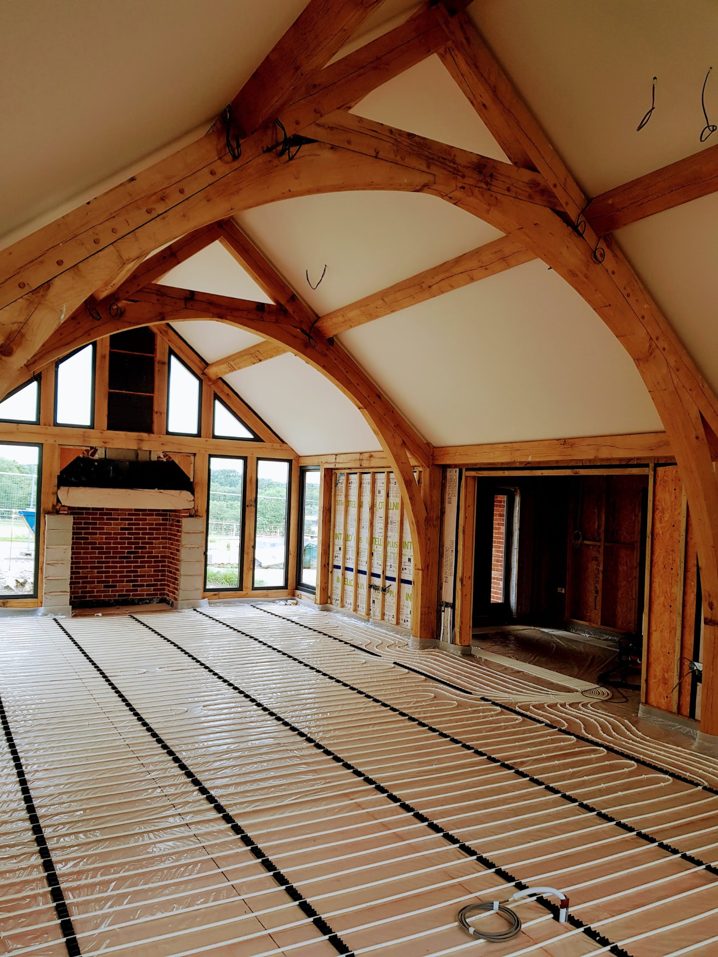 Insulated batten UFH system pipework in a vaulted oak-frame barn conversion