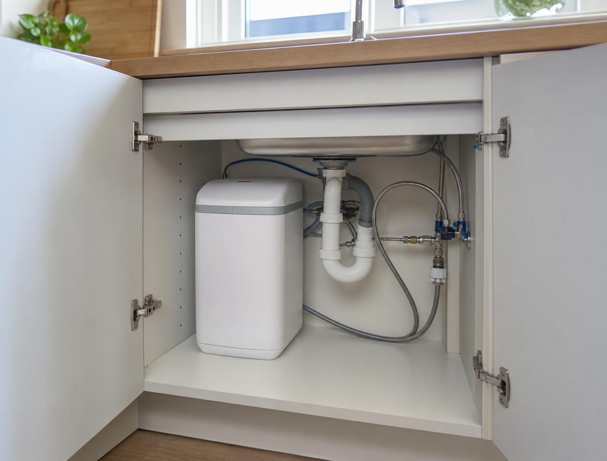 Compact softener fitted in a kitchen sink cupboard with a hard-water drinking tap bypass